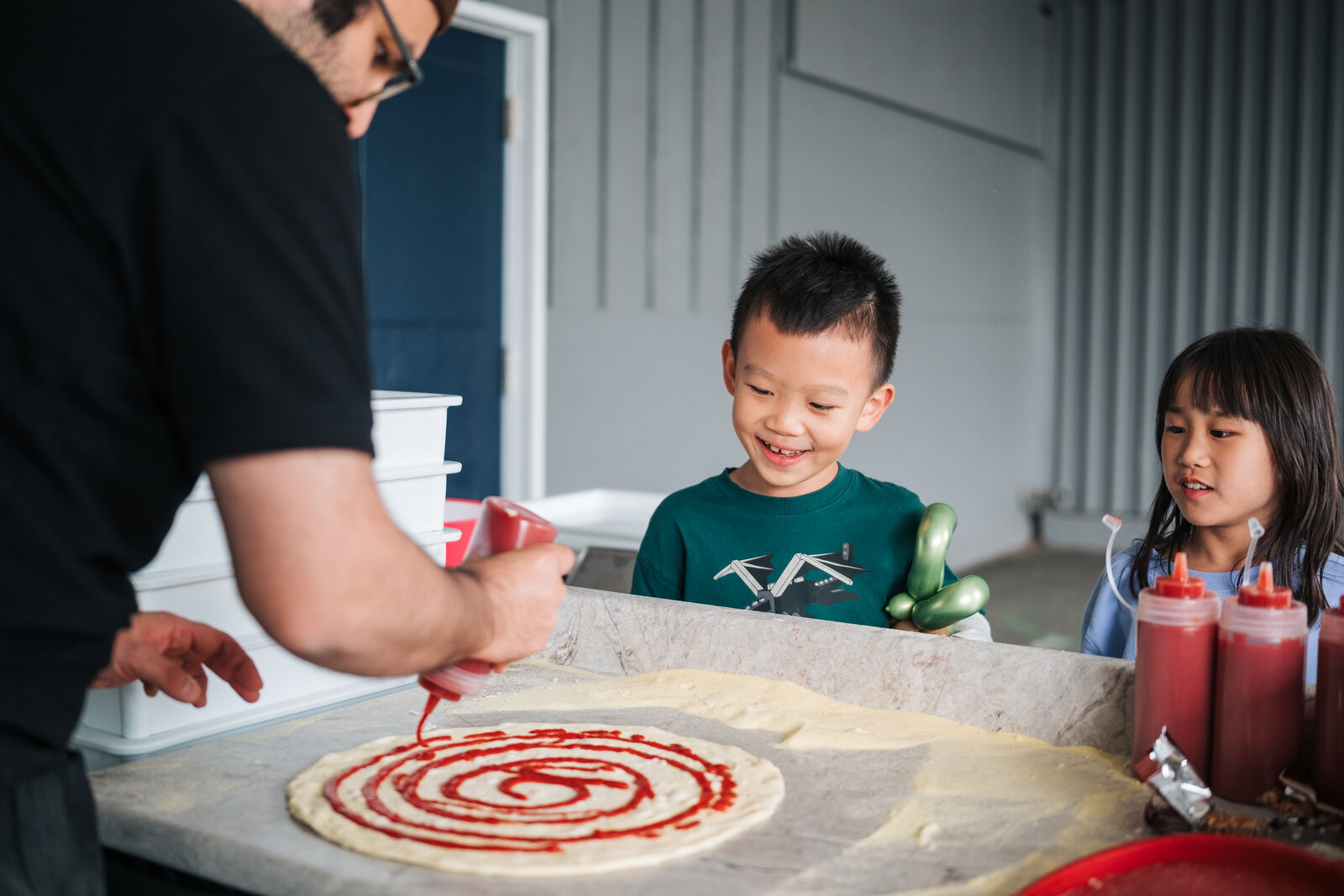 Kids watching the pizza chef toss dough in the air at Ridgeview Mayfair — mobile pizza catering Vancouver