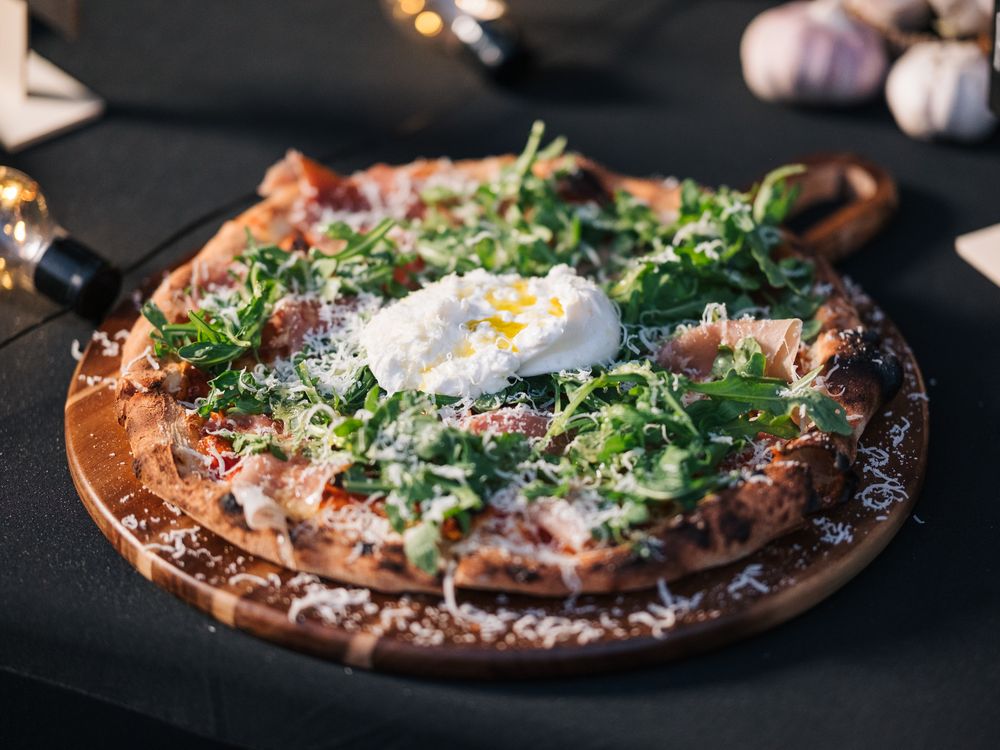 Pizza with burrata, prosciutto and arugula
