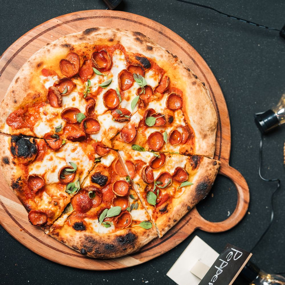 Pepperoni pizza overhead with lemons