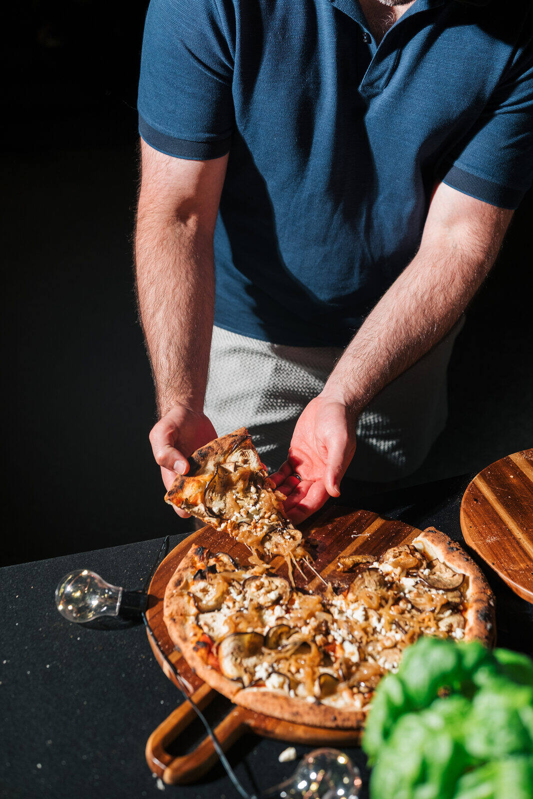 Pizza slice being lifted at a private catered event by table one. in Metro Vancouver