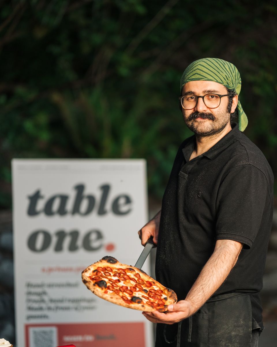 Chef with a freshly baked pepperoni pizza